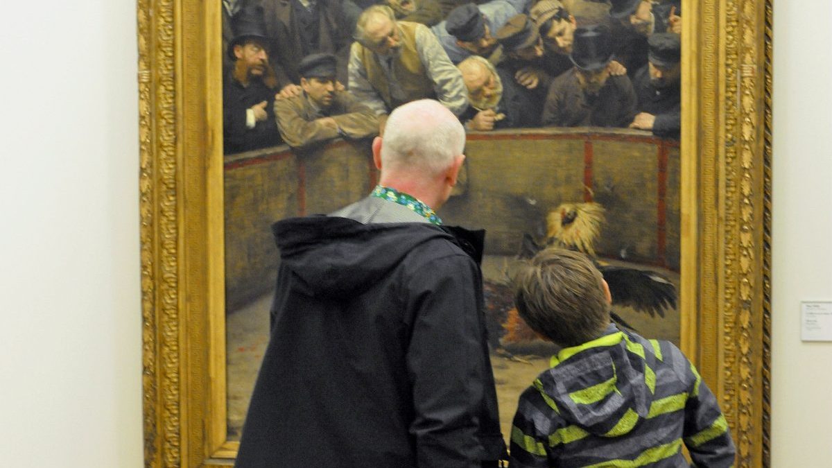 Dans une salle du musée, un adulte et un enfant observent de près un grand tableau représentant Le Combat de coqs de Remy Cogghe